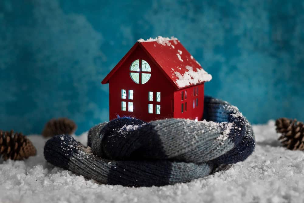 A model home wrapped in a scarf atop snow